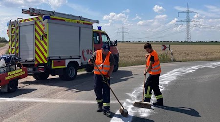 Schwere Arbeit: Die lange Ölspur muss weg. Foto: Feuerwehr Niederlommatzsch 