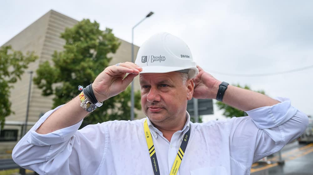 OB Dirk Hilbert dźakuje so twarskim dźěłaćerjam při Carolskim mosće.  / Foto: Robert Michael/dpa