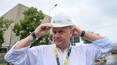 OB Dirk Hilbert dźakuje so twarskim dźěłaćerjam při Carolskim mosće.  / Foto: Robert Michael/dpa