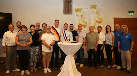 Die Stadtoberhäupter Marco Müller und Pierrick Spizak (beide mit Schärpe) sowie die Gäste aus Frankreich, Riesaer Stadträte und Vertreter von Riesa und die Welt e.V. verstanden sich sehr gut. Bürgermeister Spizak trug sich ins Gästebuch der Stadt Riesa ein. Foto: Stadt Riesa - Pressestelle