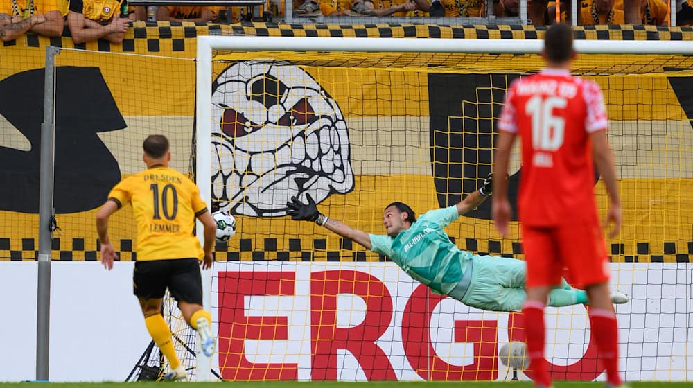 Dresden goalkeeper Tim Schreiber (M) cannot prevent the 0:1 goal. / Photo: Robert Michael/dpa