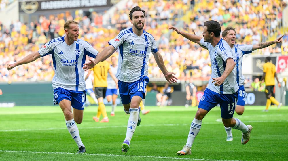 Schalke's Kenan Karaman (2nd from left) celebrates after converting his penalty / Photo: Robert Michael/dpa