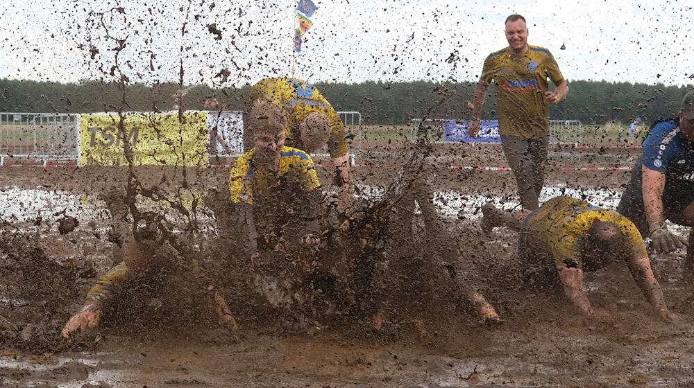 This is how mud footballers celebrate winning the championship title. This year it goes to the Lokomotive Wöllnau club / Photo: Sebastian Willnow/dpa