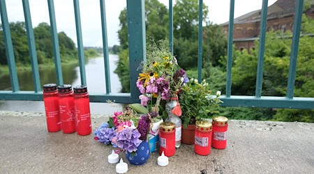 Nach dem Absturz hatten Anwohner unweit des Unglücksortes Blumen und Kerzen aufgestellt. (Archivbild) / Foto: Sebastian Willnow/dpa