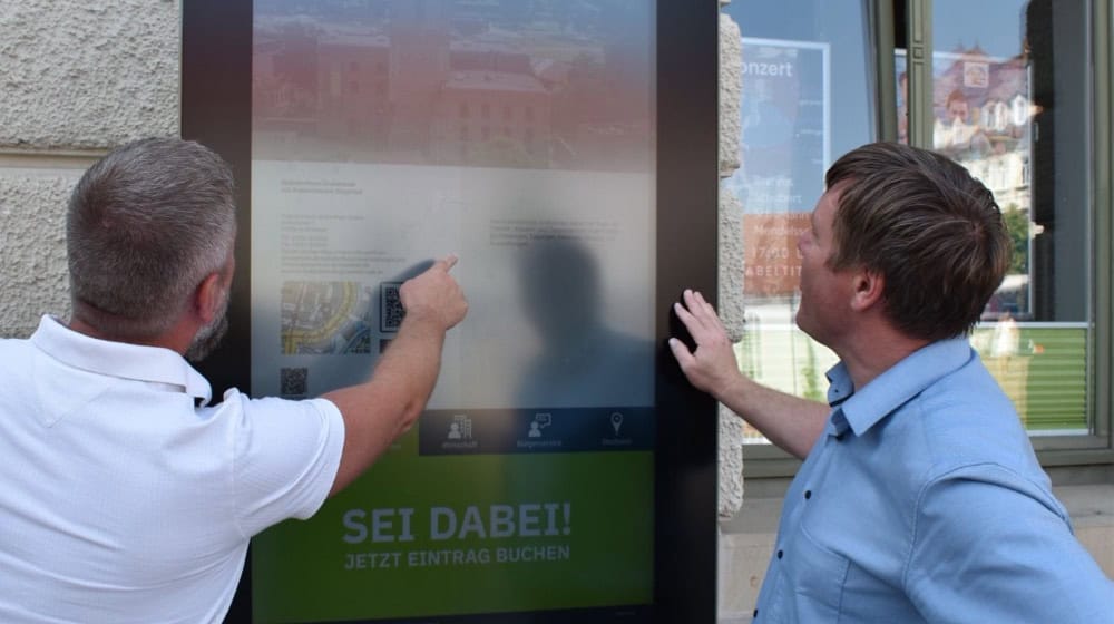 OB Sven Mißbach (r.) und Mediaberater Jens Baumgärtel testen das neue Inforterminal am Großenhainer Rathaus. Foto: Stadt Großenhain