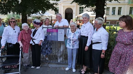 Ein besonderes Erlebnis war die Einweihung der Gedenktafel für die Große-Schwestern gemeinsam mit dem einstigen Frauentheater Meißen, der Gleichstellungsbeautragten Sabine Murcek (hinterm Zaun links) Bergsportforscher Joachim Schindler und der Vorsitzenden des Landesfrauenrates Dr. Jessica Bock für Ursula Liebau (2.v.l.) und Jutta Schuster (4.v.r).  Sie hatten Margarete Große einst als Lehrerin in der Neumarktschule erlebt. Heute befindet sich hier ein Seniorenheim. Foto: Stadt Meißen
