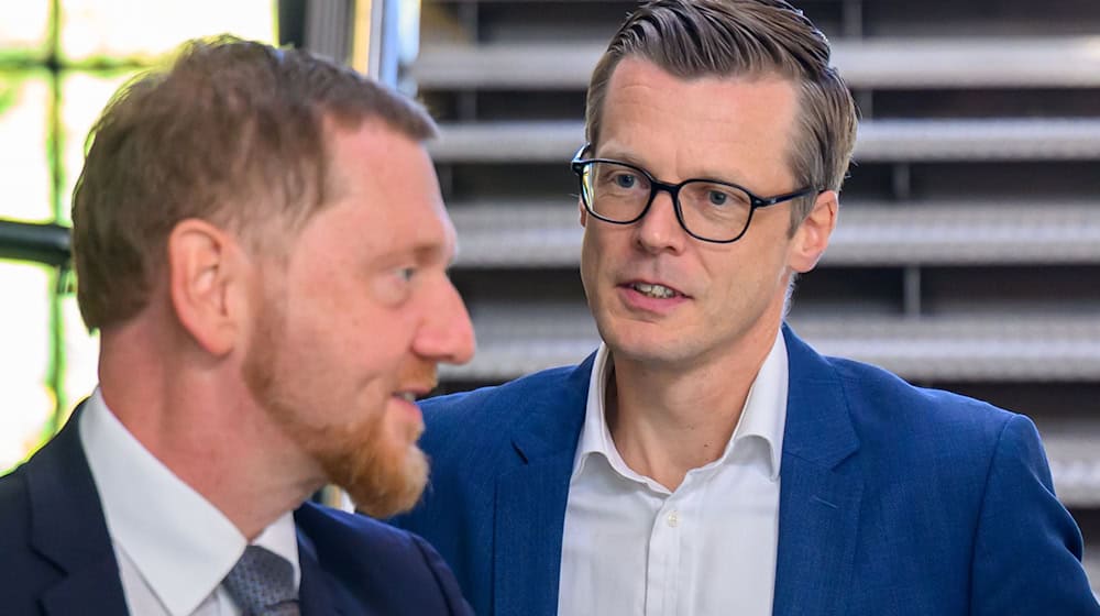 Danny Auerswald (rechts), Sprecher der Geschäftsführung von Volkswagen Sachsen, wird von Ministerpräsident Michael Kretschmer (CDU) zur Kabinettssitzung empfangen.  / Foto: Hendrik Schmidt/dpa