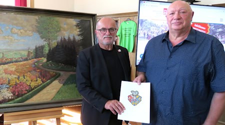Oberbürgermeister Roland Dantz (l.) und Norbert Schnabel mit der Schenkungsurkunde vor dem Ölbild aus dem Jahr 1938. Foto: Matthias Stark