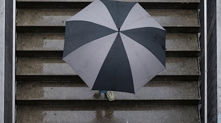 Insbesondere in Westsachsen und im Vogtland wird der Regenschirm heute zum unverzichtbaren Begleiter. (Archivbild) / Foto: Marijan Murat/dpa