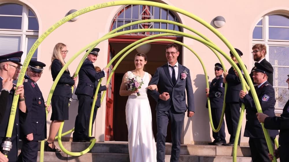 Das Feuerwehr-Brautpaar unterm Schlauchbogen. Foto: Feuerwehr