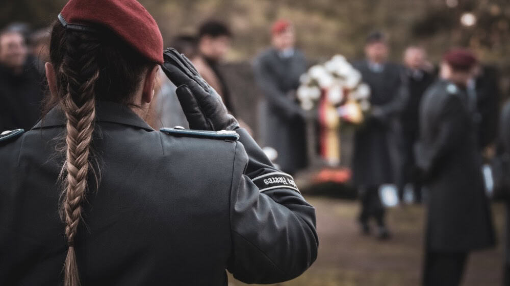 Soldatin mit Ehrengruß für die toten Kameraden am Nordfriedhof. Foto: Bundeswehr/Stübner
