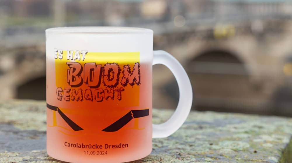 Mit einer neuen Glühweintasse erinnern Dresdner Unternehmer an den Einsturz der Carolabrücke im vergangenen Jahr. / Foto: Jürgen Lösel/dpa