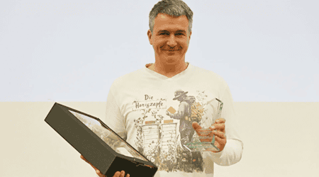 Der Meißner Imker Rico Heinzig mit seiner Auszeichnung. Foto: Deutscher Berufs- und Erwerbsimkerbund/Janine Fritsch