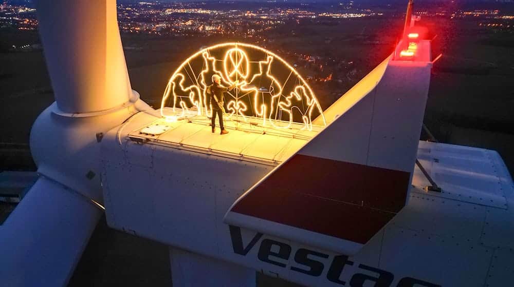 Steffen Flämig checks the lighting on an oversized candle arch on a wind turbine / Photo: Jan Woitas/dpa