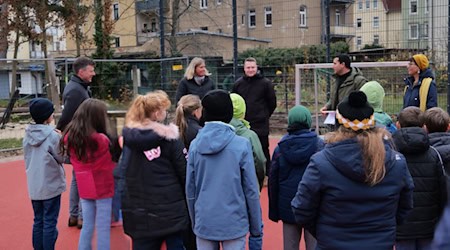 Projektleiter Schadie Mansour vom Meißner Stadtbauamt (2.v.r.) und Marion Brod-Kilian vom Landschaftsarchitekturbüro LA 21 (r.) erklärten Oberbürgermeister Markus Renner (l.), den Kindern und Kollegen aus Familienamt und Hort die Details zur Umgestaltung. Foto: Stadt Meißen
