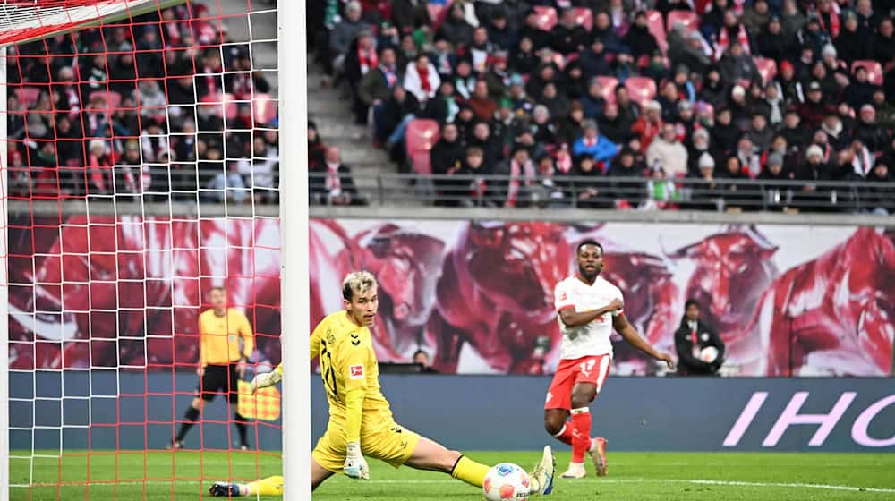 Bremen goalkeeper Mio Backhaus (l, Werder Bremen) and Ridle Baku (RB Leipzig) look after the ball. Backhaus prevented the visitors from going behind early in Leipzig with his saves / Photo: Jennifer Brückner/dpa