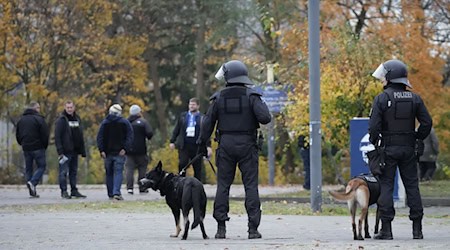Fußballfans verließen das Olympiastadion nach dem Spiel der Hertha gegen Dynamo Dresden unter den kritischen Blicken etlicher Polizisten.  / Foto: Manuel Genolet/dpa