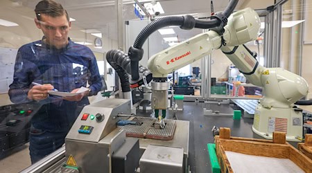 Produktionsleiter Ulrich Morawietz überwacht den Verzinn-Roboter bei Arnold Electronic in Lichtenau. Entwickelt hat das Familienunternehmen die Anlage zusammen mit dem Institut Chemnitzer Maschinen- und Anlagenbau ICM.  / Foto: Jan Woitas/dpa