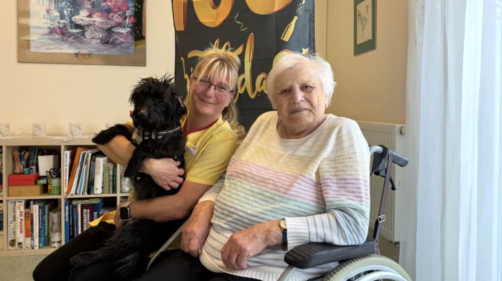 Hilde Franken zusammen mit der Leiterin der ASB-Tagespflege Annett Kazar und ihrem Hund Karl, der zur Feier des Tages mit Fliege geschmückt wurde. Foto: Sabine Mutschke