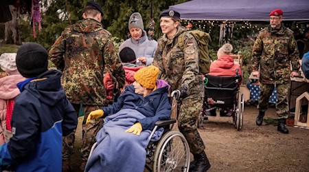 Offizierschüler mit Heimbewohnern auf dem Weihnachtsmarkt. Foto: Bundeswehr/Pilz