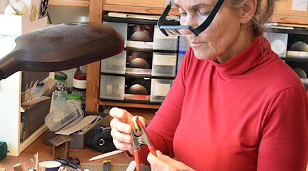 Winzige Bücher mit mehr als 90 Seiten stellt Kathrin Hohensee aus Leipzig her und bringt ganze Städte und Abenteuer in die Puppenstube. / Foto: Waltraud Grubitzsch/dpa