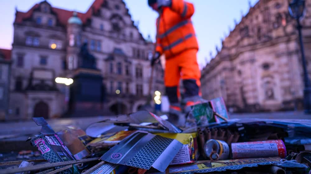 Nach der Silvesternacht räumen Mitarbeitende der Stadtreinigung in der Dresdner Innenstadt tonnenweise Böllerreste, Raketenstiele und Glas von Straßen und Plätzen (Archivbild) / Foto: Robert Michael/dpa