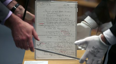 Mitarbeiter stülpen im Haus der Geschichte eine Glasvitrine über den Schabowski-Zettel. Um das Ausstellungsstück gibt es seit Jahren Streit mit einem Journalisten. (Archivbild) / Foto: picture alliance / dpa