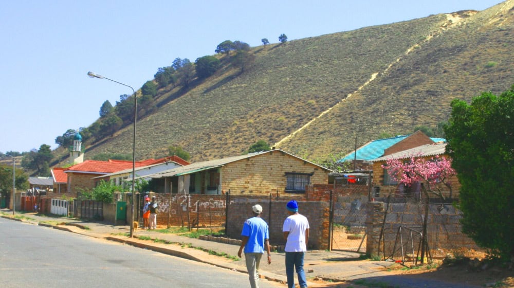 In the Witwatersrand Basin near Johannesburg, families live right next to spoil heaps from gold mining. The swirling dust contains toxic uranium. Angela Mathee