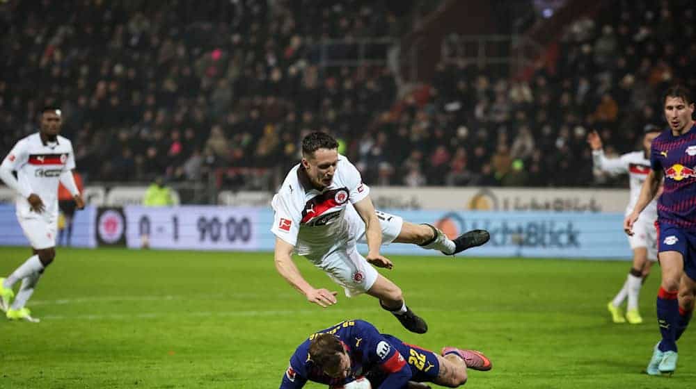 Пенальті в компенсований час: гравець "Лейпцига" Давид Раум (внизу) фолить на нападнику "Санкт-Паулі" Мартіну Каарсу (вгорі) - / Фото: Крістіан Харізіус/dpa