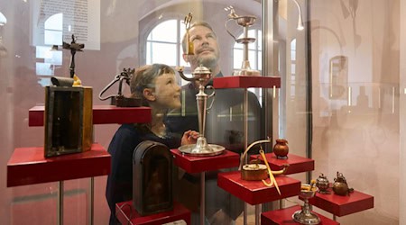 Vater und Tochter an der Vitrine mit Kerzenscheren im Museum Schloss Klippenstein. Foto: Juliane Mostertz