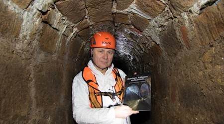 Experte Frank Männig zeigt im ältesten Kanal Dresdens hinter der Schinkelwache sein Buch über die Dresdner Entwässerungsgeschichte. Das stellt er bei einer Lesung am 27. Januar, 16 Uhr, im Klärwerk Kaditz vor. Foto: Peter Hilbert