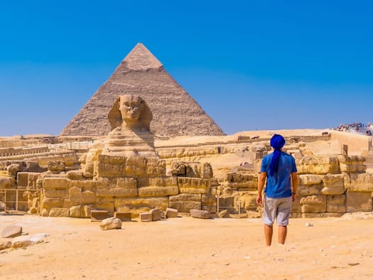 Tourist vor der Sphinx und der Cheops-Pyramide von Gizeh in Ägypten bei sonnigem Wüstenwetter