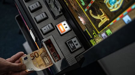 Geld wird in einem Spielautomaten gesteckt. Mehrere solcher Maschinen beschlagnahmten Beamte der Polizei in Görlitz. (Symbolbild) / Foto: Bernd Thissen/dpa