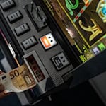 Geld wird in einem Spielautomaten gesteckt. Mehrere solcher Maschinen beschlagnahmten Beamte der Polizei in Görlitz. (Symbolbild) / Foto: Bernd Thissen/dpa