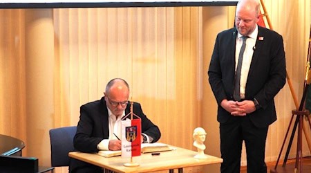 OB a.D. Roland Dantz (l.) trägt sich im Beisein von Oberbürgermeister Michael Preuß in das Goldene Buch der Stadt Kamenz ein. Foto: PR Stadt Kamenz