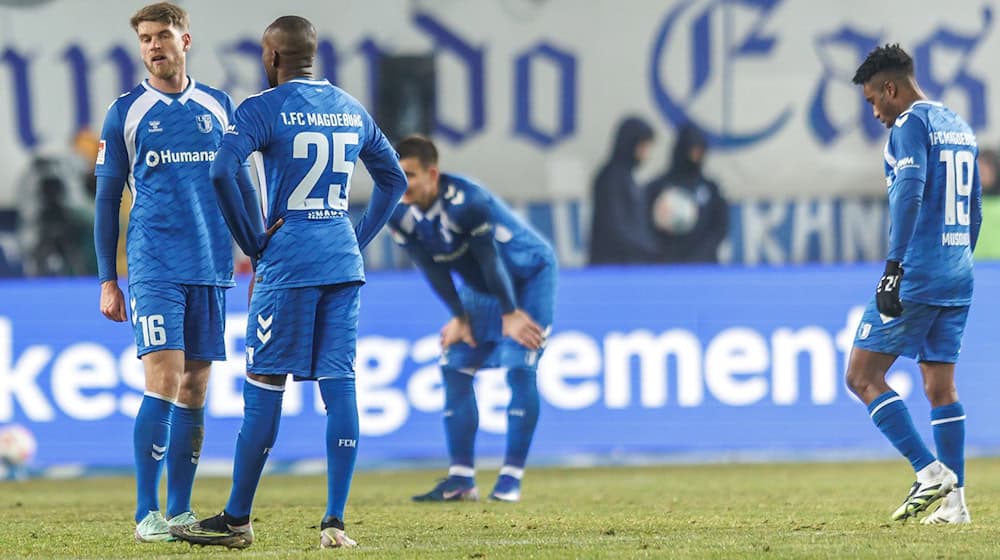 Disappointed Magdeburg fans after the home defeat against Hannover / Photo: Andreas Gora/dpa