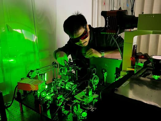 Millionen Mal kleiner als sichtbar: Dr. Diptabrata Paul steuert das Experiment, in dem winzige Partikel das Schwimmen lernen – ganz ohne Sensoren.