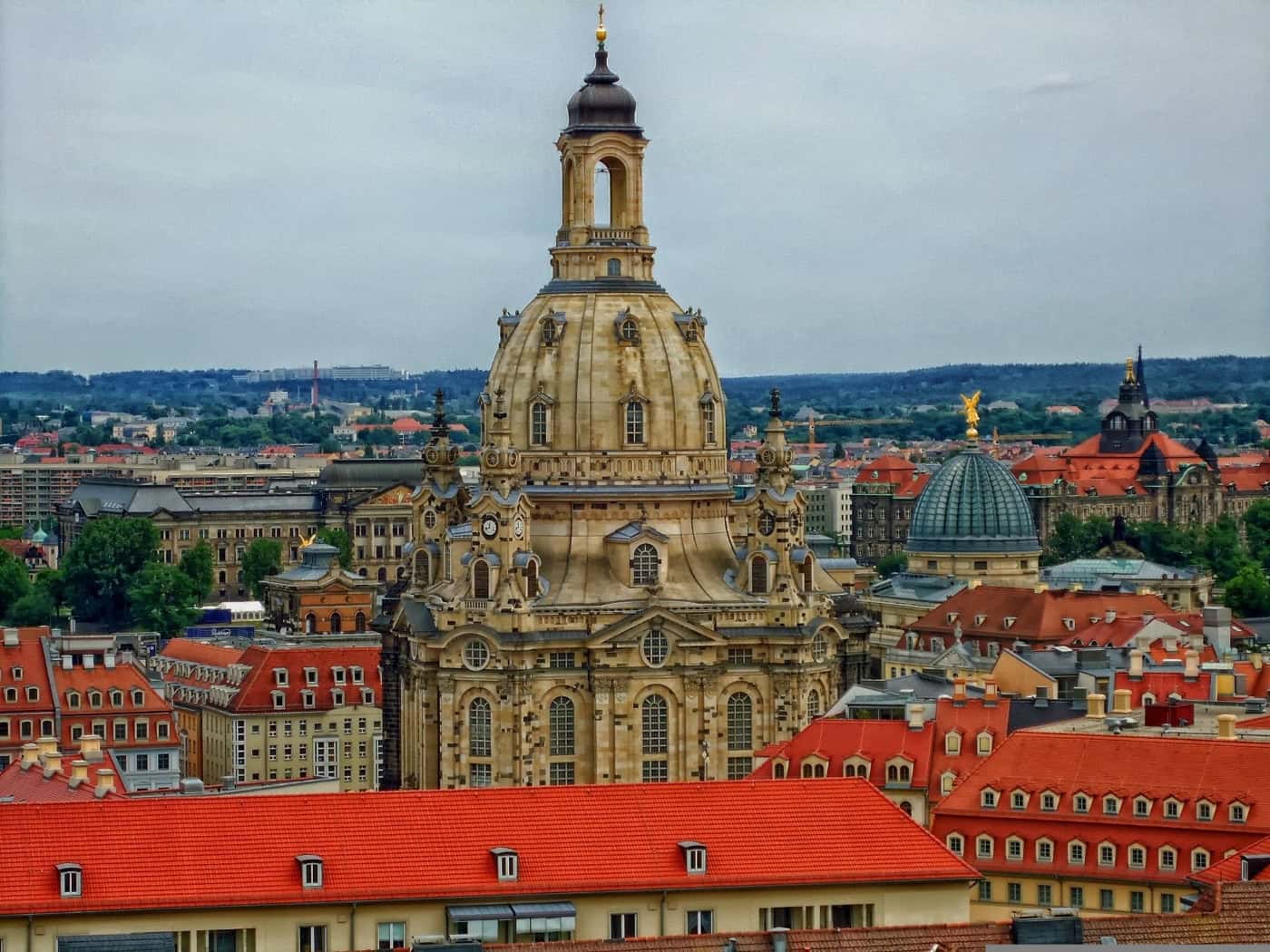 Panorama der Dresdner Altstadt mit der markanten Kuppel der Frauenkirche und umliegenden Wohn- und Geschäftshäusern mit roten Ziegeldächern.