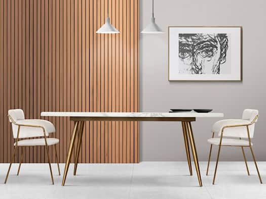 Modernes Esszimmer mit Holzpaneelen an der Wand, weißem Tisch, goldenen Stühlen und Pendelleuchten – zeigt Akustikpaneele aus Holz als stilvolles Gestaltungselement für Innenräume