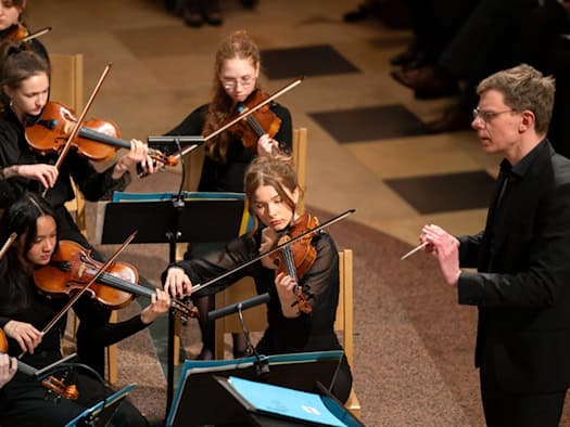 Der Dirigent Sebastian Dietrich leitet mit dem Taktstock in der Hand ein junges Streicherensemble in der Dresdner Kreuzkirche.