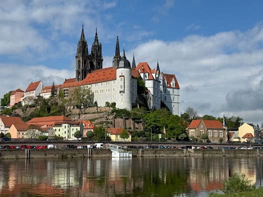 Foto: Blick über die Elbe auf die hoch aufragende Burg Meißen, im Hintergrund Türme des Doms