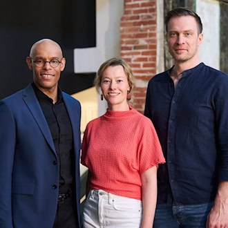 Michael Ellis Ingram (links), Kathrin Kondaurow (Mitte) und Matthias Reichwald (rechts) stehen gemeinsam vor dem Logo der Staatsoperette Dresden bei der Vorstellung des neuen Programms.
