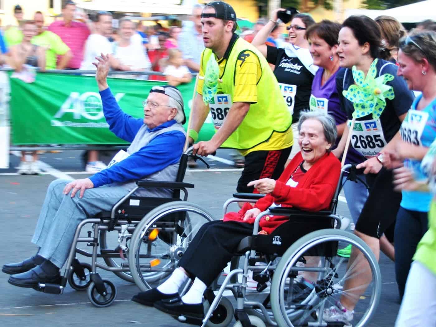 Symbolfoto zum Thema Inklusion und Teilhabe: Menschen mit und ohne Rollstuhl nehmen gemeinsam an einer fröhlichen Outdoor-Veranstaltung teil. Das Bild vermittelt Lebensfreude und gegenseitige Unterstützung und steht stellvertretend für die vielfältigen Angebote der Dresdner Inklusionswoche.