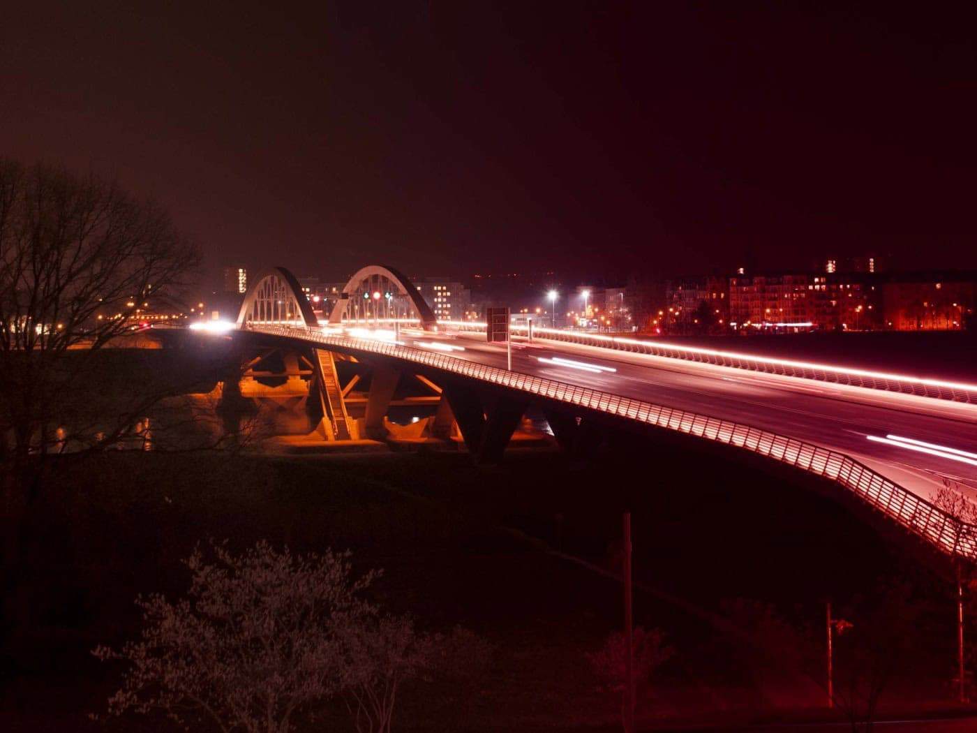 Langzeitbelichtung der Waldschlößchenbrücke in Dresden bei Nacht mit roten und weißen Lichtspuren des fließenden Verkehrs.