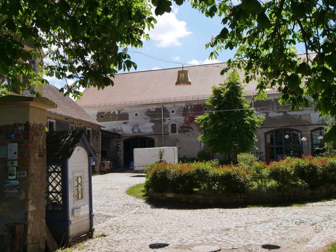 Foto: Blick durch das Tor in den Innenhof eines alten Bauernhofs