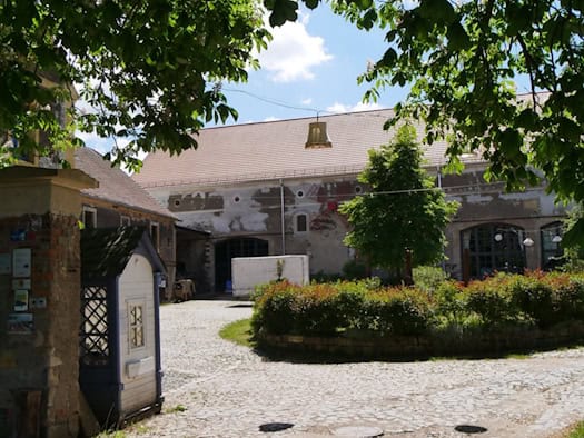 Foto: Blick durch das Tor in den Innenhof eines alten Bauernhofs
