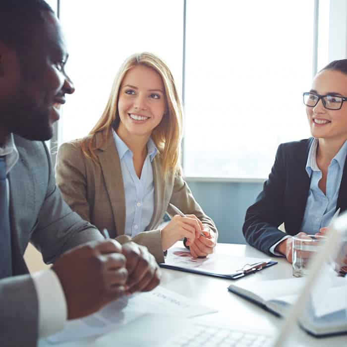 Drei Geschäftsleute diskutieren im Meeting über B2B-Lizenzstrategien und Verträge