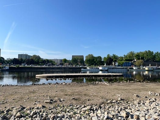 Blick über die Elbe auf den aktuellen Standort der Carolabrücke in Dresden bei blauem Himmel.