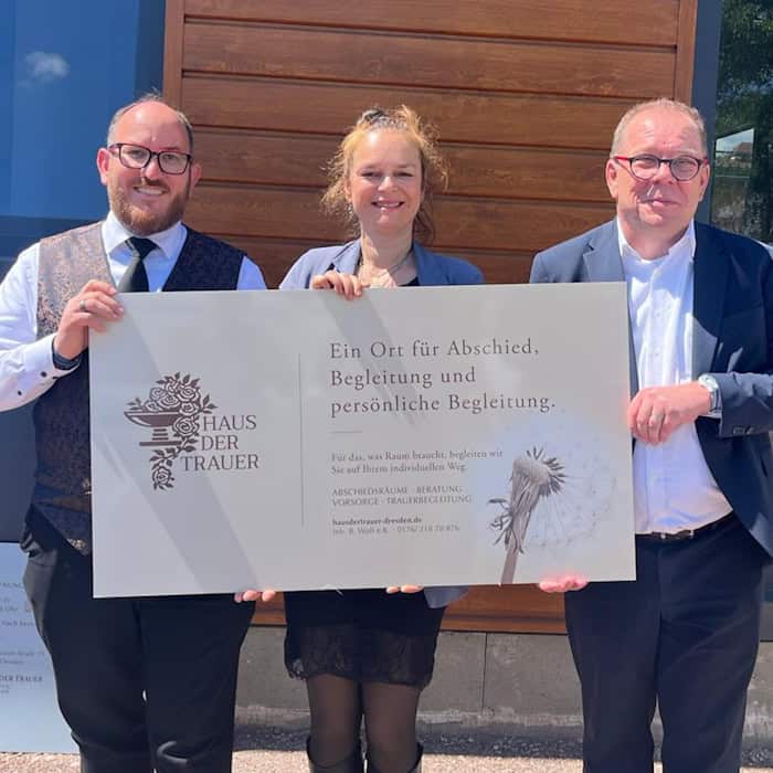 Drei lächelnde Personen stehen nebeneinander in den sanierten, lichtdurchfluteten Räumen des neuen Instituts: Links das Inhaber-Ehepaar Adriana und Benjamin Wolf, rechts im Bild der Beteiligungsmanager der SIB Innovations- und Beteiligungsgesellschaft.