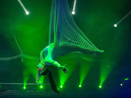 Artistin bei einer waghalsigen Vorführung am Schwungtrapez unter der Zirkuskuppel des Circus ARENA.
